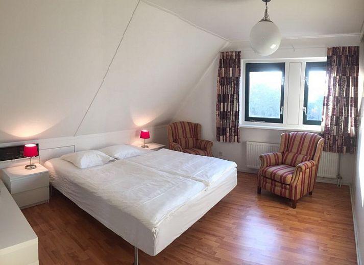 Moderne keuken in Huis op Duynopgangh, Julianadorp, vakantiehuis aan de Noordzeekust, met strakke witte kasten en uitzicht op de tuin.