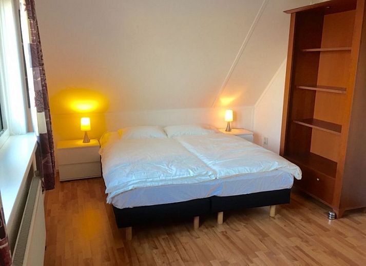 Moderne keuken in Huis op Duynopgangh, Julianadorp, vakantiehuis aan de Noordzeekust, met strakke witte kasten en uitzicht op de tuin.