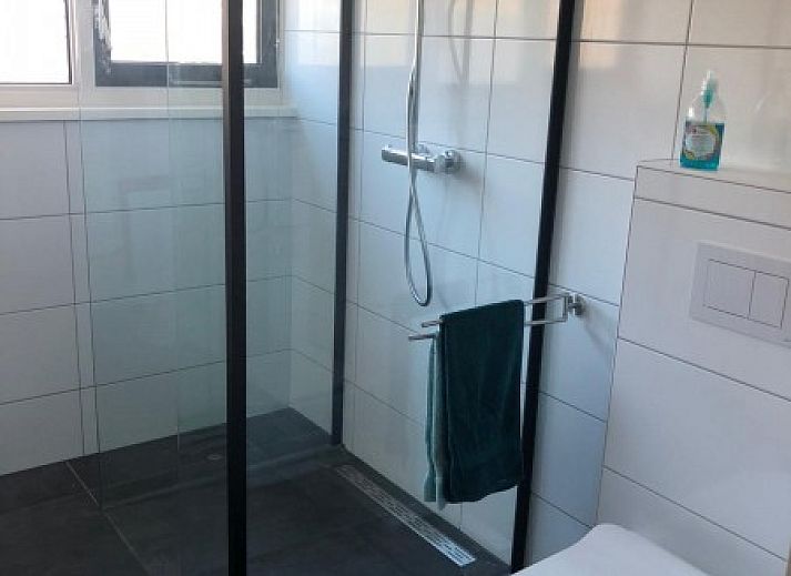 Ruime keuken van Huis op Duynopgangh in Julianadorp, vakantiehuis aan de Noordzeekust, met houten vloer en stijlvolle inrichting.