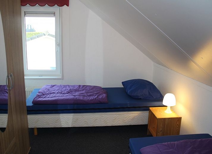 Blick von der ueberdachten Terrasse des Ferienhauses Visvriend in Wervershoof, Nordholland mit Garten und Wasser.