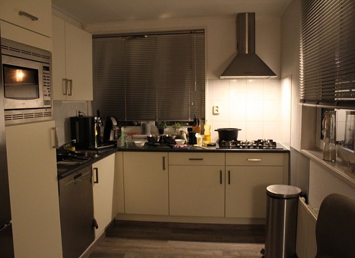 Blick von der ueberdachten Terrasse des Ferienhauses Visvriend in Wervershoof, Nordholland mit Garten und Wasser.