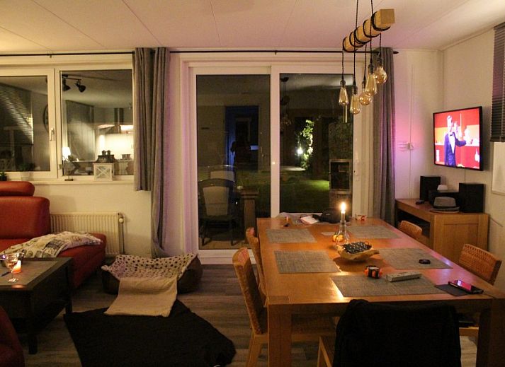 Blick von der ueberdachten Terrasse des Ferienhauses Visvriend in Wervershoof, Nordholland mit Garten und Wasser.