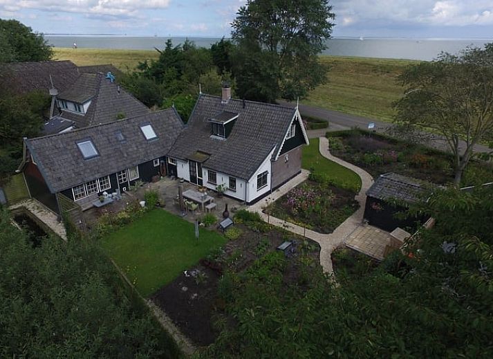 Luchtfoto van Vakantiehuis in Andijk aan de IJsselmeerkust, omringd door groen en uitzicht op het meer in Noord-Holland.