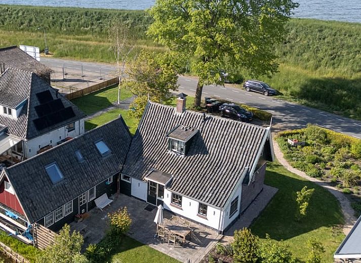 Charmante entree van Vakantiehuis in Andijk, met houten gevel in Noord-Holland, gelegen aan de serene IJsselmeerkust.