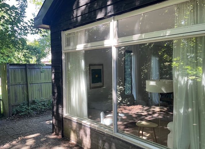 Geraeumiges Wohnzimmer des Ferienhauses in Andijk, IJsselmeerkueste, Nordholland mit bequemer Sitz- und Essecke.