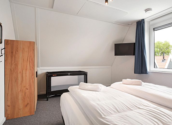 Gezellige zithoek met kachel in Volendam 4CA appartement, perfect voor een knusse avond aan de IJsselmeerkust, Noord-Holland.