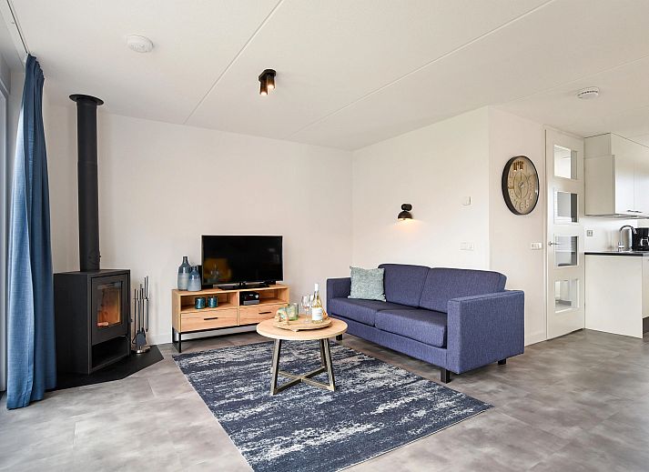 Gezellige zithoek met kachel in Volendam 4CA appartement, perfect voor een knusse avond aan de IJsselmeerkust, Noord-Holland.