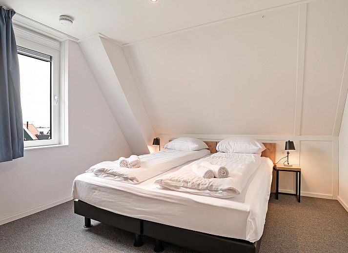 Gezellige zithoek met kachel in Volendam 4CA appartement, perfect voor een knusse avond aan de IJsselmeerkust, Noord-Holland.