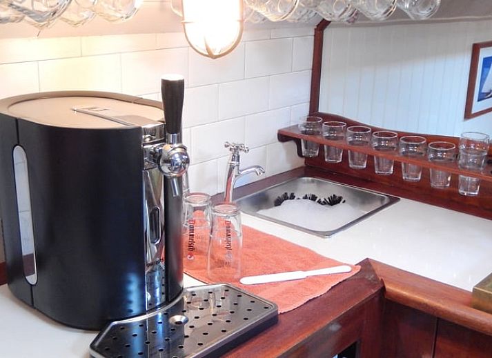 Huisje in Muiden biedt een gezellige binnenruimte met houten interieur en eethoek, ideaal voor een vakantie aan de IJsselmeerkust.