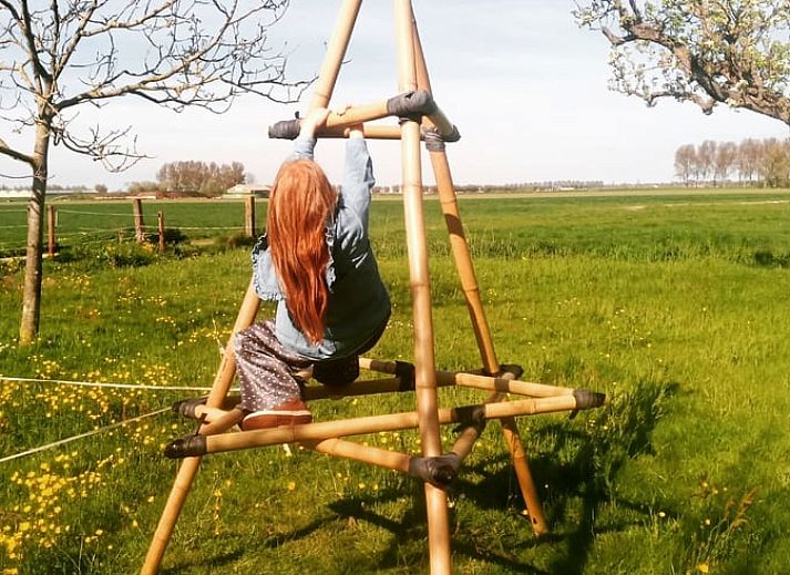 Blick auf die Landschaft vom Ferienhaus in Hem, Nordholland, mit spielendem Kind.