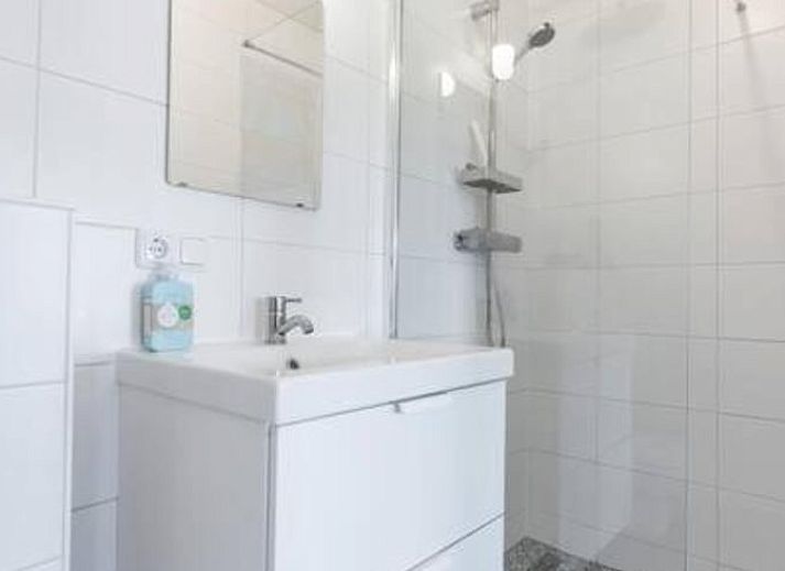 Geraeumiges Wohnzimmer im Ferienhaus in Hem, IJsselmeerkueste mit bequemen Sofas und grosser Lampe.