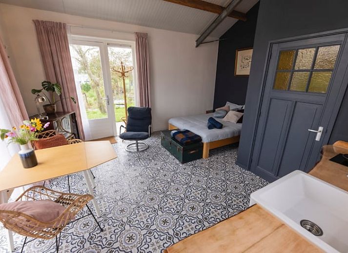 Gezellige woonkamer in Huisje in Hem, vakantiehuis in Hem, Noord-Holland met retro inrichting en uitzicht op de natuur.