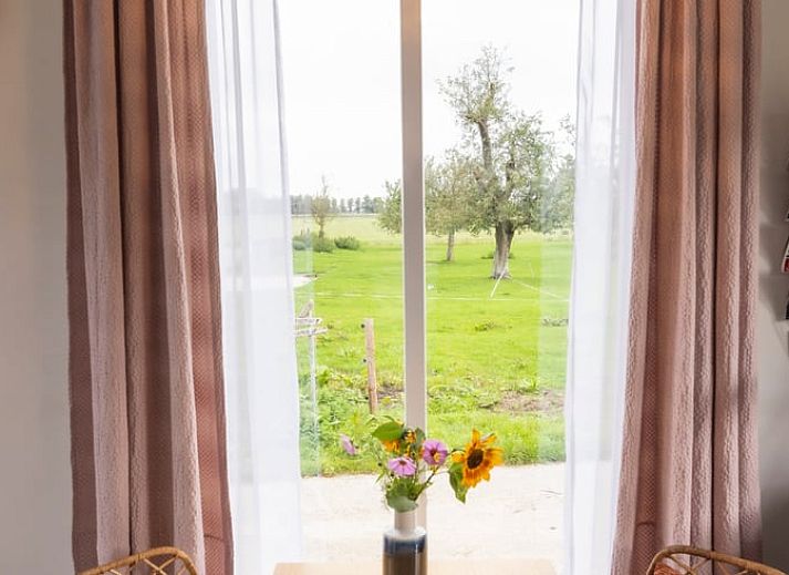 Gezellige woonkamer in Huisje in Hem, vakantiehuis in Hem, Noord-Holland met retro inrichting en uitzicht op de natuur.
