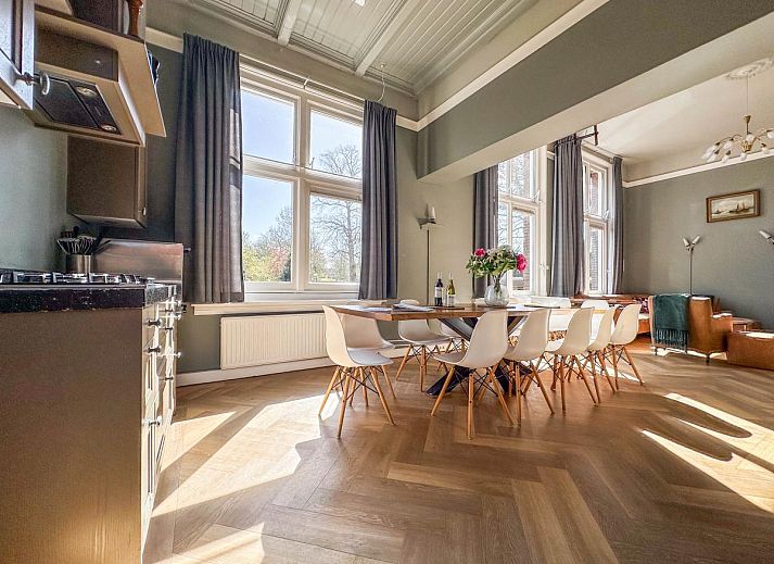 Lichte woonkamer van Groot Weeshuis vakantiehuis in Enkhuizen, Noord-Holland met ruime zithoek en grote ramen met uitzicht op de natuur.