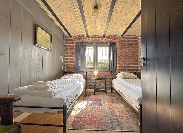 Gezellige eetkamer in vakantiehuis Groot Weeshuis, Enkhuizen, met ruime tafel en veel natuurlijk licht, gelegen aan de IJsselmeerkust, Noord-Holland.