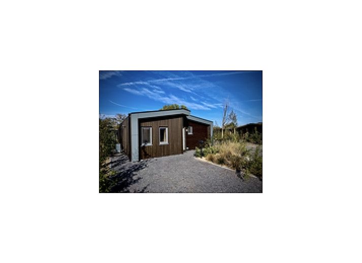 Freistehendes Haus in Enkhuizen, ein Ferienhaus an der Kste des IJsselmeers in Nordholland, umgeben von einem natrlichen Garten und blauem Himmel.