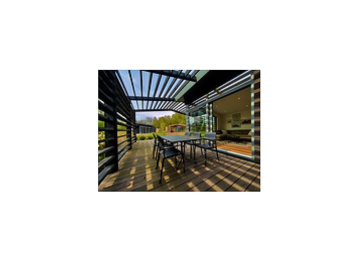 Freistehendes Haus in Enkhuizen, ein Ferienhaus an der Kste des IJsselmeers in Nordholland, umgeben von einem natrlichen Garten und blauem Himmel.