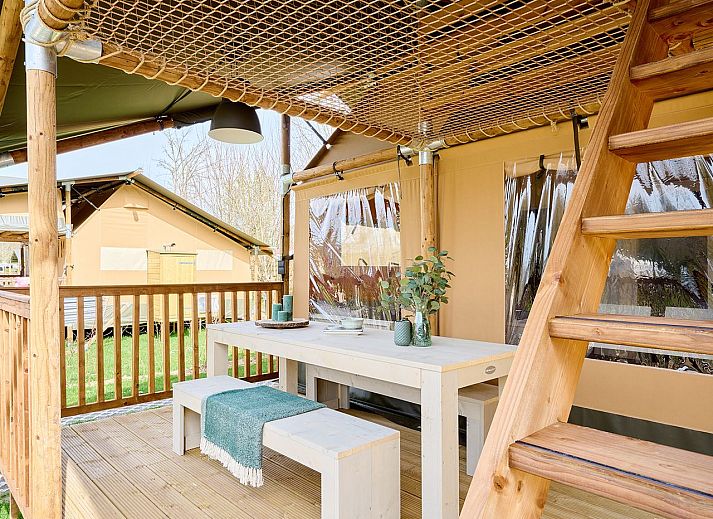 Gezellige binnenruimte van safaritent 6-8ST in Huizen, met eettafel en moderne faciliteiten.