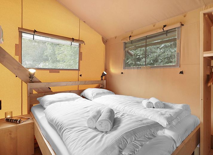 Cozy terrace of 4-6 person safari tent 4-6S1 in Houses, with wooden furniture and bar.