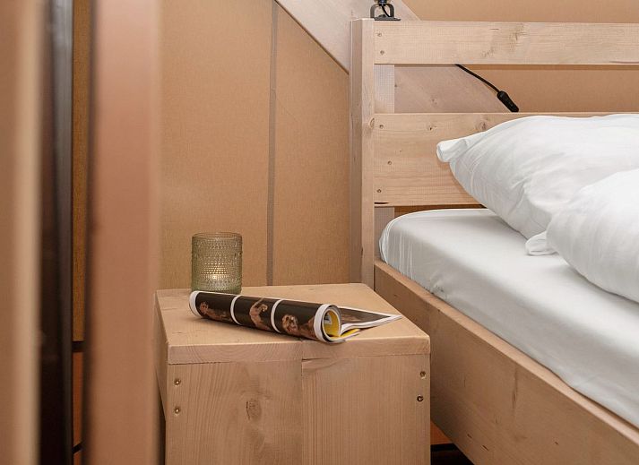 Indoor area of safari tent 4-6S1 in Huizen, North Holland, with comfortable sitting area and view of terrace.