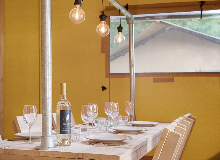 Indoor area of safari tent 4-6S1 in Huizen, North Holland, with comfortable sitting area and view of terrace.