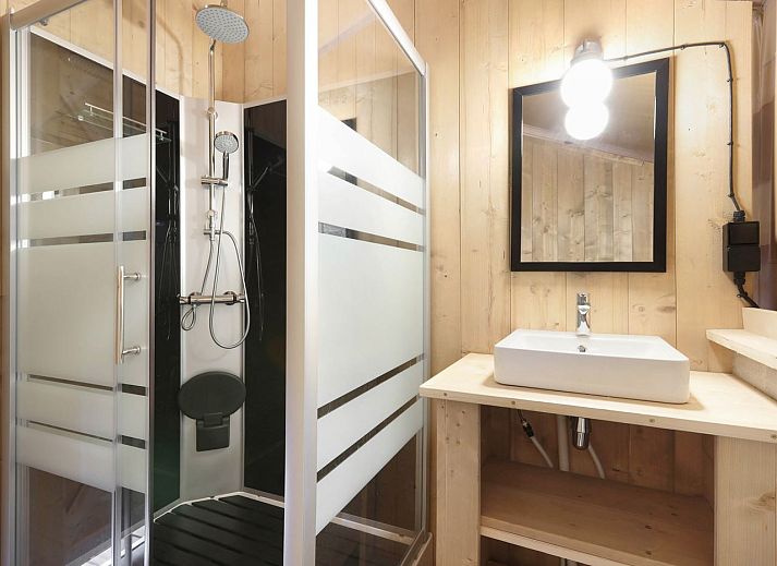 Indoor area of safari tent 4-6S1 in Huizen, North Holland, with comfortable sitting area and view of terrace.