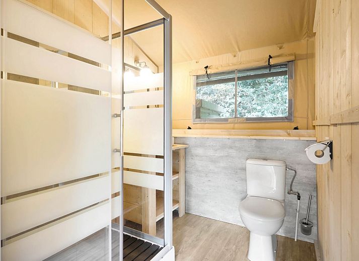 Spacious living space in glamping lodge 4-6S1 in Houses, with dining area and kitchen facilities.