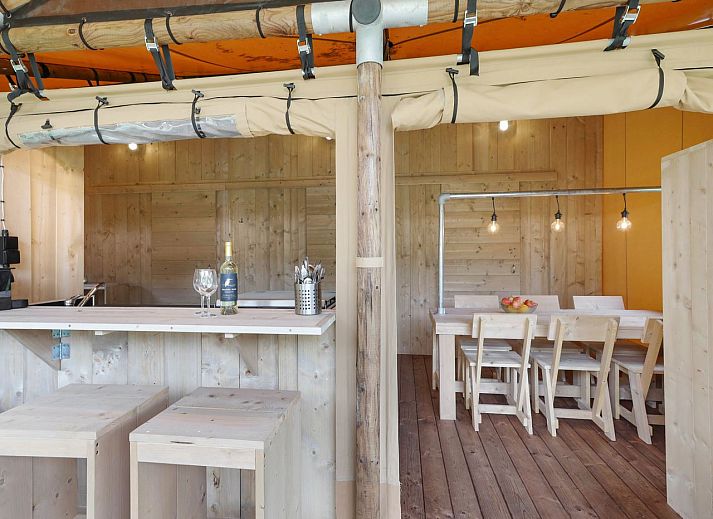 Spacious living space in glamping lodge 4-6S1 in Houses, with dining area and kitchen facilities.