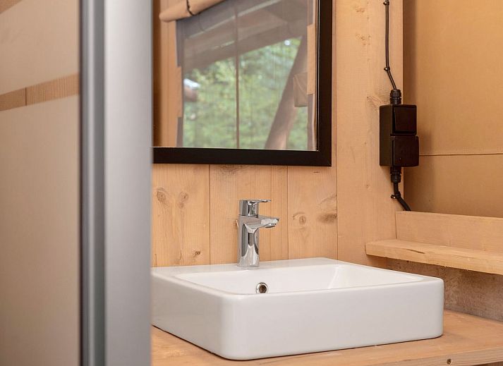 Spacious living space in glamping lodge 4-6S1 in Houses, with dining area and kitchen facilities.