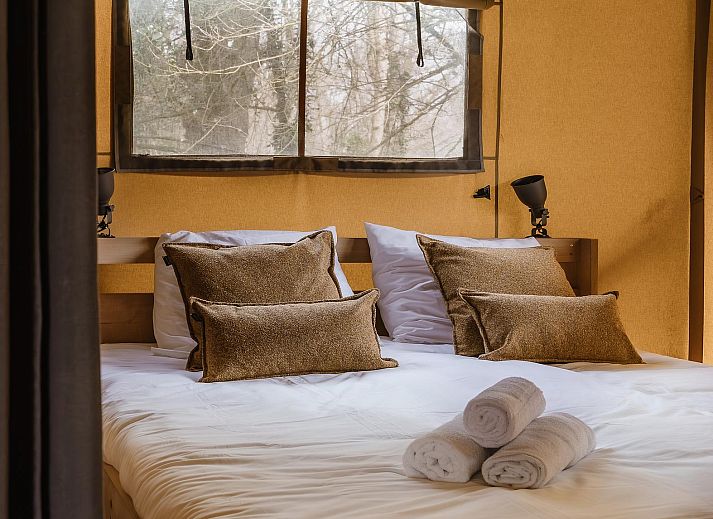Gezellige slaapkamer in De Bos Tent, een sfeervolle glamping lodge in Huizen, Noord-Holland, met knusse inrichting en natuurlijk licht.