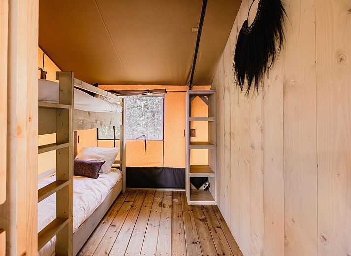 Gezellige binnenruimte van De Bosvilla in Huizen, Noord-Holland, met knusse kachel en zithoek voor een ontspannen vakantieverblijf.