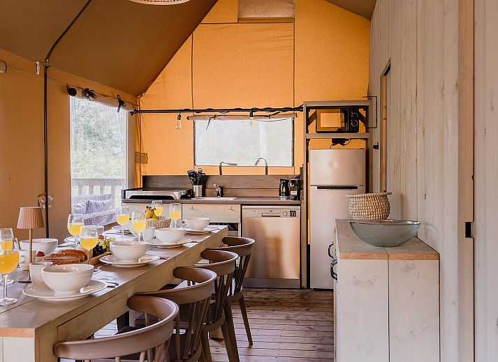 Gezellige binnenruimte van De Bosvilla in Huizen, Noord-Holland, met knusse kachel en zithoek voor een ontspannen vakantieverblijf.