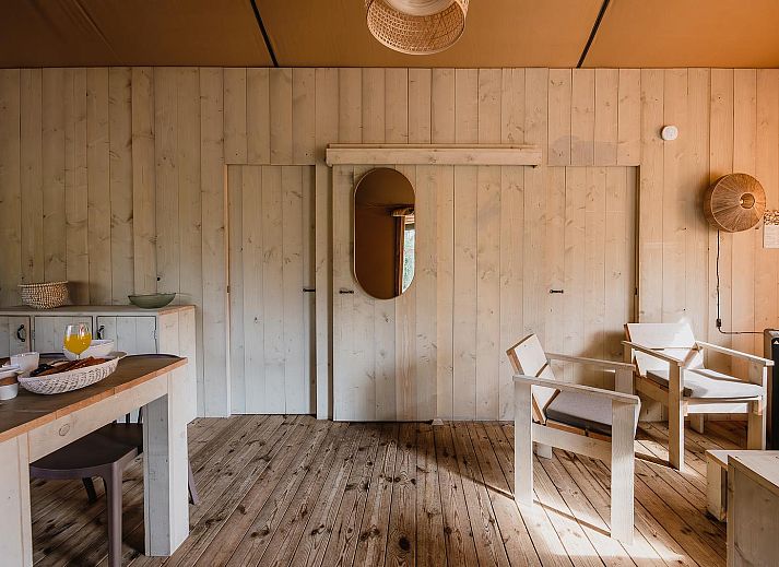 Geniet van een stijlvol gedekte tafel in De Bosvilla, een luxe tenthuis in Huizen, IJsselmeerkust, met uitzicht op de natuurlijke omgeving.