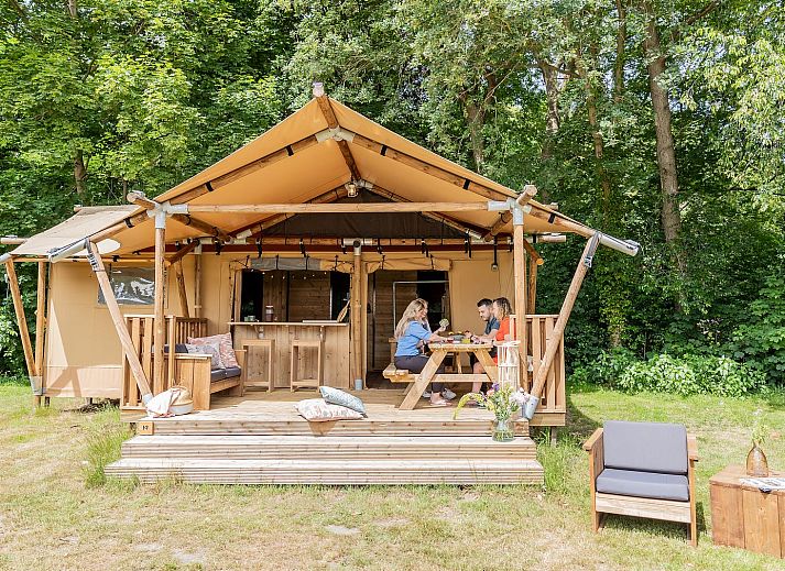 De Heide Tent in Huizen, North Holland offers a cozy glamping experience with an inviting terrace surrounded by green nature.