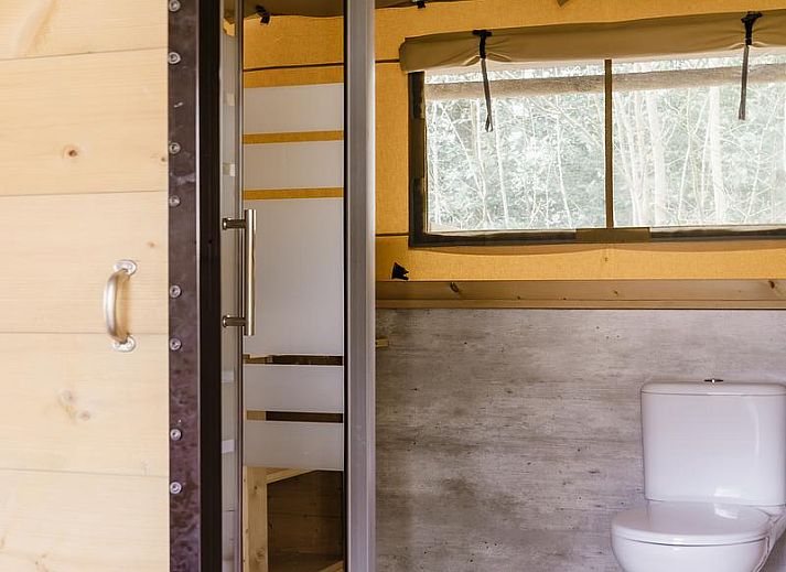 Gezellige binnenruimte van De Heide Tent in Huizen, Noord-Holland, met open keuken en uitzicht op de natuurlijke omgeving.