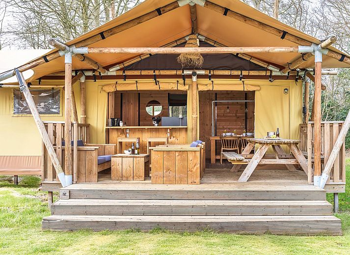 Gezellige binnenruimte van De Heide Tent in Huizen, Noord-Holland, met open keuken en uitzicht op de natuurlijke omgeving.