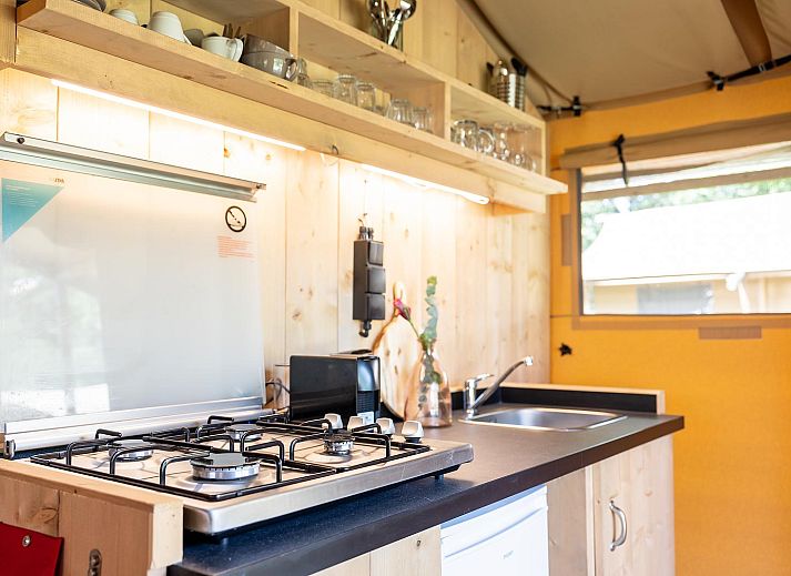 De Bos Tent in Huizen, IJsselmeer coast, North Holland offers an attractive glamping experience with a veranda and natural surroundings.