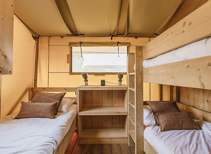 Gezellige binnenruimte van De Bos Tent in Huizen, IJsselmeerkust, met houten interieur en complete keuken, ideaal voor een glamping ervaring.