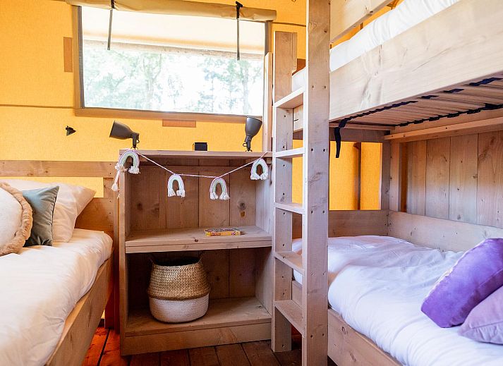 De Bos Escape glamping lodge in Huizen, Noord-Holland, omgeven door groene natuur en voorzien van een ruime veranda voor een ontspannen verblijf.