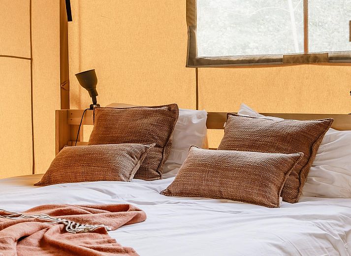 De Bos Escape glamping lodge in Huizen, Noord-Holland, omgeven door groene natuur en voorzien van een ruime veranda voor een ontspannen verblijf.