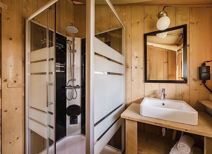 Gezellige binnenruimte van De Bos Escape in Huizen, Noord-Holland met keuken en eetgedeelte, ideaal voor een glamping ervaring.