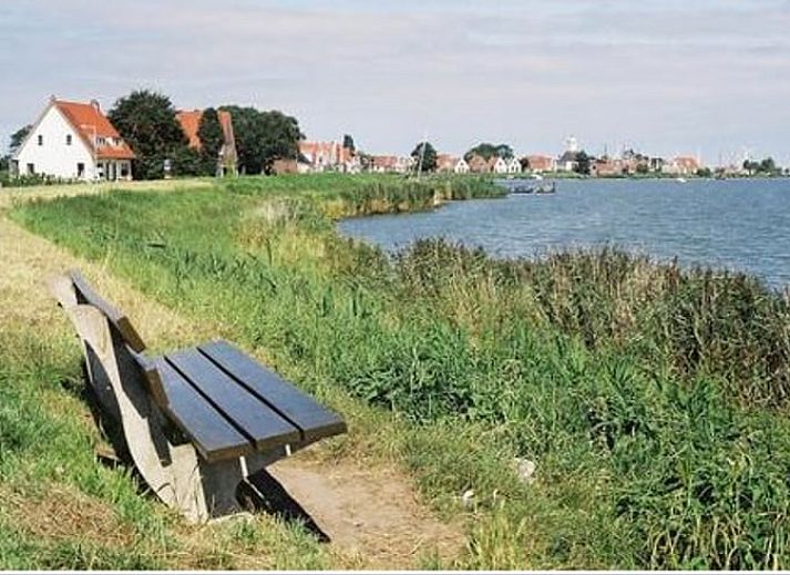 Aussenansicht des Ferienhauses in Katwoude, umgeben von bluehenden Pflanzen in Katwoude, IJsselmeerkueste, Nordholland.