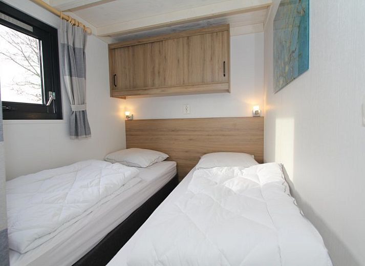 Gezellige woonkamer in Chalet EuroParcs Markermeer, Bovenkarspel, met uitzicht op terras en natuur.