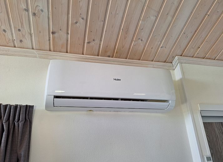 Gezellige woonkamer in Chalet EuroParcs Markermeer, Bovenkarspel, met uitzicht op terras en natuur.