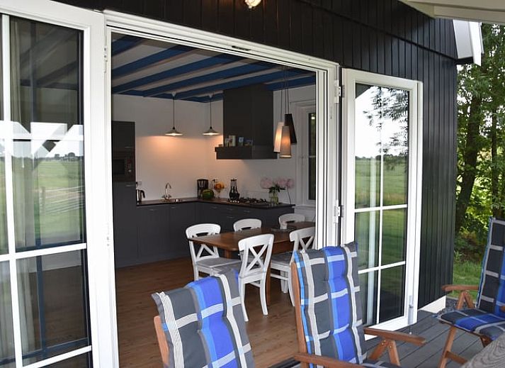 Erleben Sie Komfort im gemuetlichen Wohnzimmer des Ferienhauses in Schellinkhout, mit Blick auf die natuerliche Umgebung der IJsselmeerkueste.