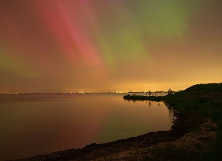 Erleben Sie Komfort im gemuetlichen Wohnzimmer des Ferienhauses in Schellinkhout, mit Blick auf die natuerliche Umgebung der IJsselmeerkueste.