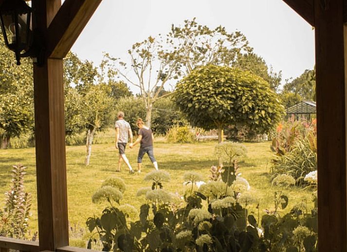 Gemuetlicher Innenraum des Ferienhauses in Benningbroek, Ferienhaus an der Kueste des IJsselmeers, Nordholland, mit komfortabler Sitzecke und Doppelbett.