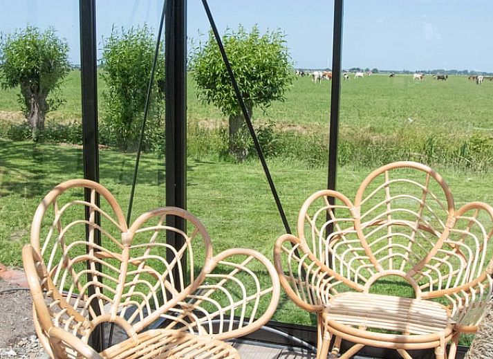 Gemuetlicher Innenraum des Ferienhauses in Benningbroek, Ferienhaus an der Kueste des IJsselmeers, Nordholland, mit komfortabler Sitzecke und Doppelbett.