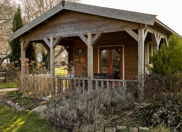 Gemuetlicher Innenraum des Ferienhauses in Benningbroek, Ferienhaus an der Kueste des IJsselmeers, Nordholland, mit komfortabler Sitzecke und Doppelbett.