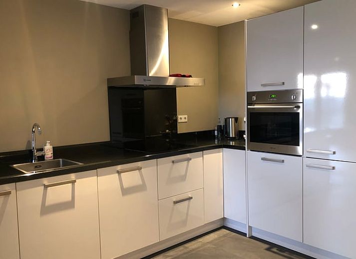 Gemuetliches Wohnzimmer im Ferienhaus in Anna Paulowna, Nordholland mit bequemer Sitzecke und Gartenblick.